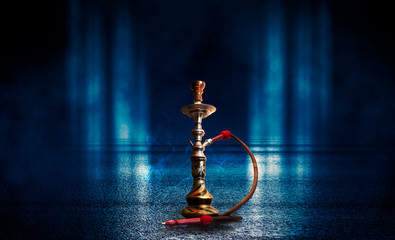 Hookah smoking on a dark abstract background. Background of empty scenes with neon lights and...