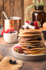 Delicious, only cooked sweet pancakes with frozen berries on a white plate. American traditional dish. High calorie and nutritious breakfast.