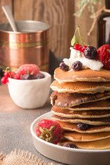 Delicious, only cooked sweet pancakes with frozen berries on a white plate. American traditional dish. High calorie and nutritious breakfast.