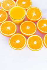 Halved oranges fruit and glass of juice. Citrus for making juice. A lot of sliced oranges on a white background. Background of oranges. Top view