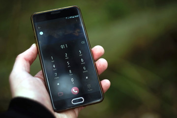 Mobile phone in hand dialing emergency 911