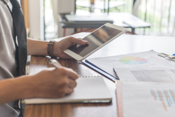 Side view of young man writing notes in office