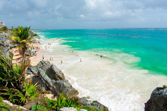 Aerial view on Beautiful Paraiso Beach in Tulum, Mexico. People in water Coast of Caribbean Sea. 