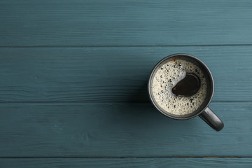 Cup of coffee on wooden background, top view