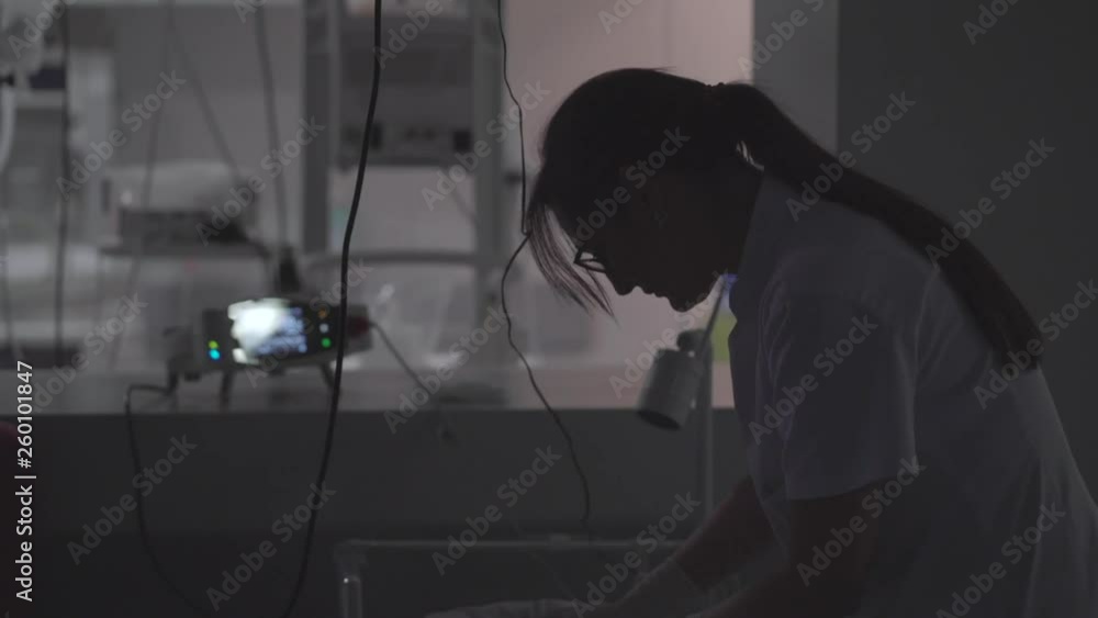 Wall mural female doctor examining newborn baby in the night. night shift