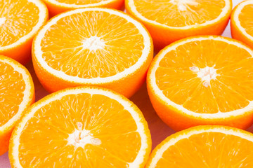 Background of oranges fruits. Many halves of fresh oranges, top view. Citrus for making juice. A lot of sliced oranges on a white background. Concept