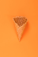 Sweet wafer cone isolated on orange background.