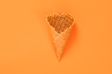 Sweet wafer cone isolated on orange background.