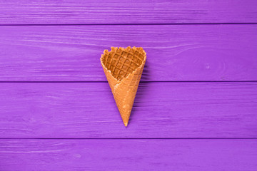 Sweet wafer cone isolated on violet background.