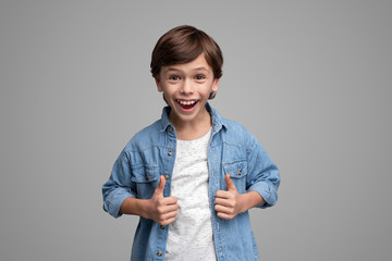 Excited boy gesturing thumb ups