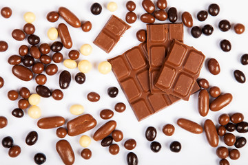 Milk chocolate pieces isolated on white background from top view