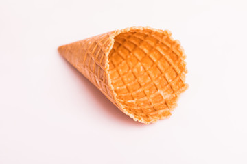 Waffle cornet isolated on light pink background.