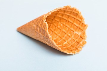 Waffle cornet isolated on light blue background.