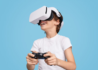 Cheerful boy playing videogame in VR goggles © kegfire