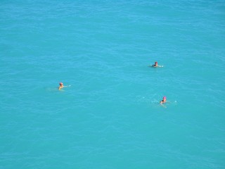 drei Schwimmer mit pinken Badehauben 
