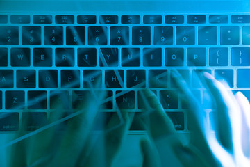 A computer programmer or hacker prints a code on a laptop keyboard to break into a secret organization system.