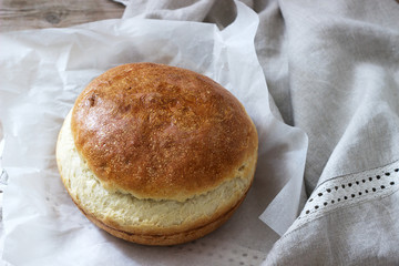 Fresh homemade wheat yeast bread on a linen tablecloth. Rustic style.