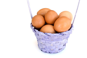 Isolated closeup of a pile of brown chicken eggs lying in a wicker basket. Easter concept