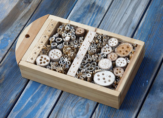 Insect hotel made of reed and drilled holes in wood of different diameter to suit all kind of insects
