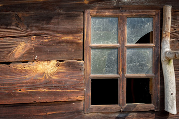 The old window of old wooden house. Background of wooden walls