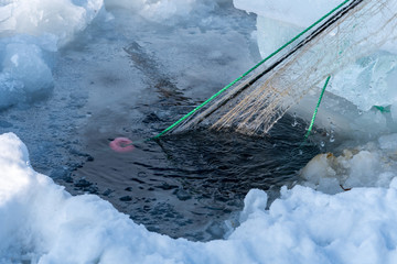 Catching fish with fishing net outdoor activities in winter time.