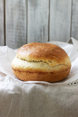 Fresh homemade wheat yeast bread on a linen tablecloth. Rustic style.