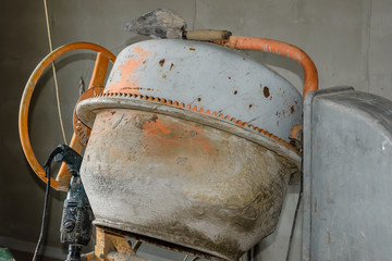 Concrete mixer and hammer drill at the construction site