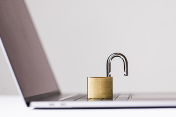 Laptop with opened padlock on white background. Space for text.