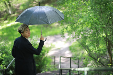 Spring rainy weather and a young man with an umbrella