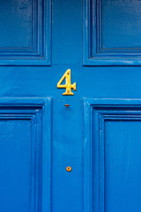Flirty four in shiny yellow on a blue wooden door
