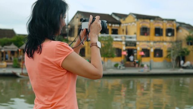 Attractive woman taking pictures of beautiful city views in Vietnam. Slow motion people footage.