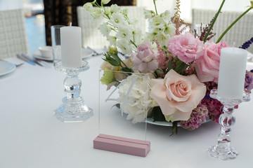 Event white restaurant table served and decorated with delicate fresh flowers