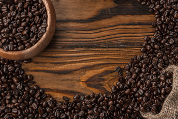 Coffee beans in a round plate on a wooden table. Copy space