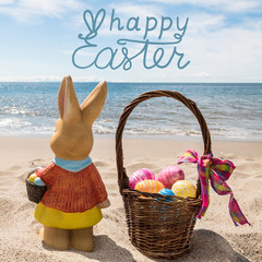 Happy Easter bunny with basket and color eggs on the ocean beach