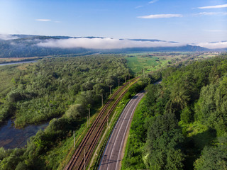 aerial view road with railway station in mountains with forest