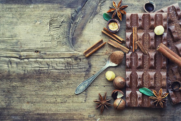 A bar of milk chocolate on the table. Chocolate with nuts and cinnamon.