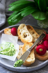 Butter with wild garlic, slices of bread and radish, ingredients for making a sandwich.
