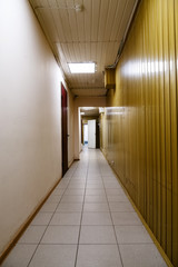 Long empty corridor with doors inside of old office building