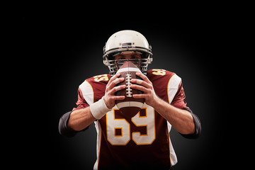 Portrait of American football player holding a ball with both his hands