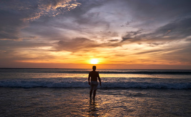 Fototapeta premium Man watching sunset on the beach