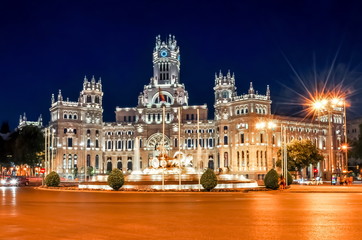 Cybele palace and fountain on Cibeles square at night, Madrid, Spain