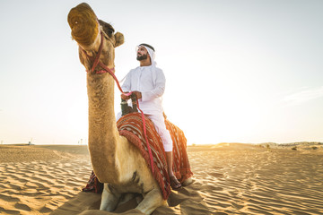 Arabian man with camel in the desert - Powered by Adobe