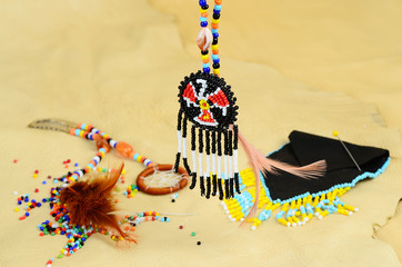 Selective Focus on Thunderbird Medallion with Native American Artifacts on Buckskin BG