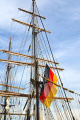 The flag of Germany flutters on a mast of the sailing vessel