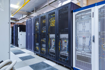 Control modules with modern communication equipment, switches and cables in server room. Data...