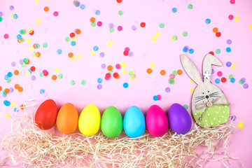 Fototapeta na wymiar Colored Easter eggs on pink background. Flatlay.