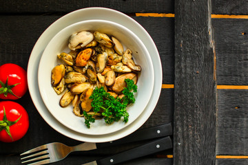 mussels A serving of seafood is a white plate. food background. top image