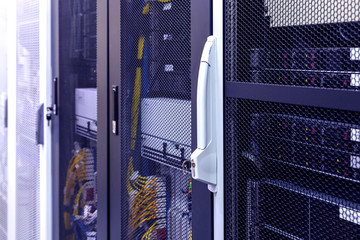 Row of racks in big data center inside close up. Datacentre interface and equipment.