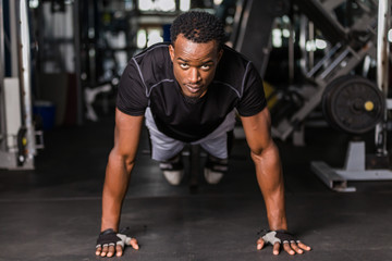 Fototapeta na wymiar Black African American young man doing workout at the gym