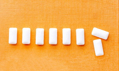 Chewing gums white in the form of pillows are in row